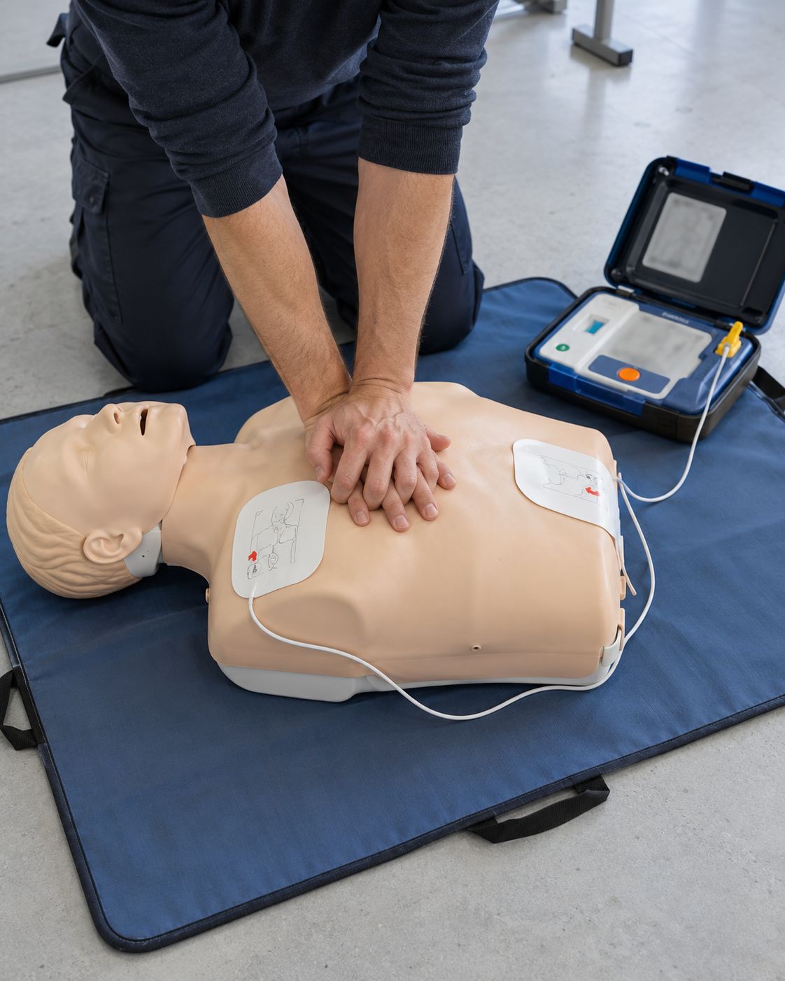 Compressioni toraciche su un manichino per la rianimazione, con le piastre del defibrillatore applicate